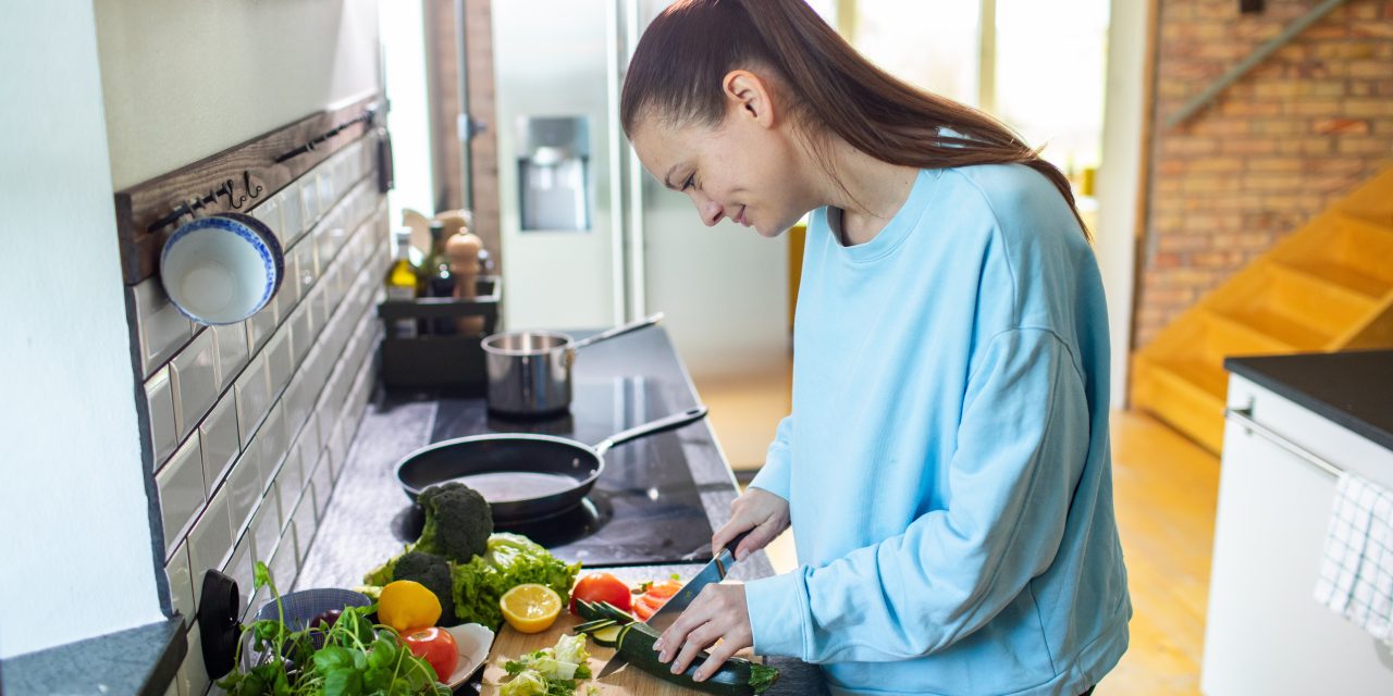 Young,Adult,Woman,Preparing,A,Healthy,Salad,In,The,Kitchen